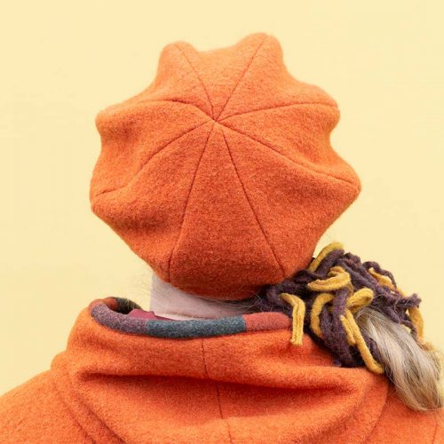 Oranssi villahattu, talvihattu. Baskerimainen muoto, jossa lierimäinen lippa edessä.
