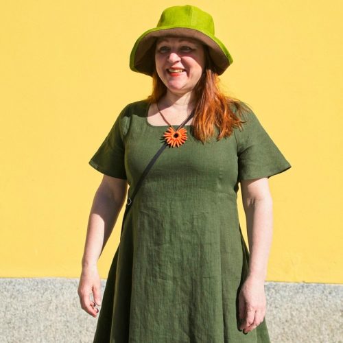 Vihreä pellavainen mekko, jossa epäsymmetrinen kaunis liehuva helma ja lyhyet hihat